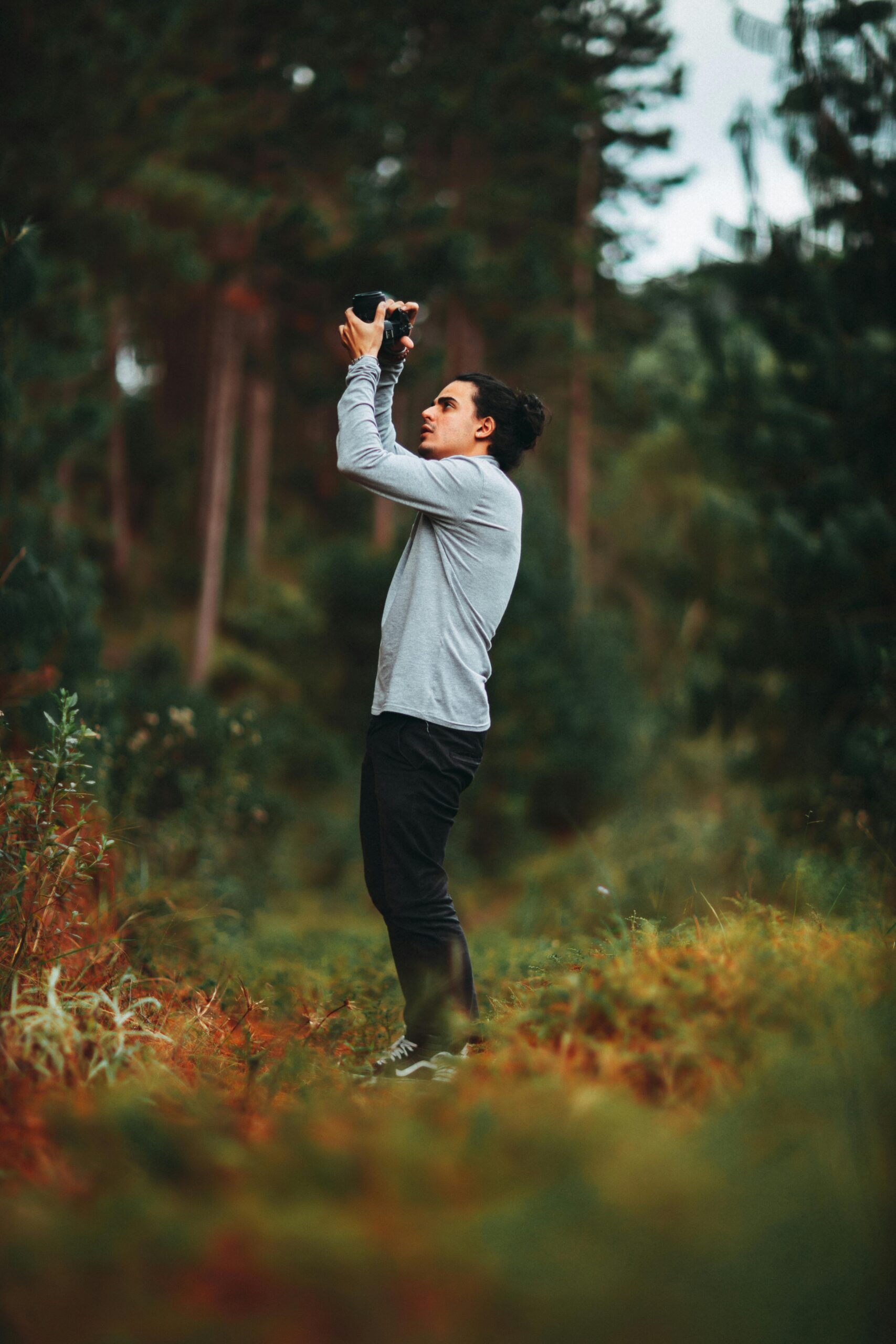 “Homem fotografando a natureza, representando conexão com o ambiente e bem-estar mental.”