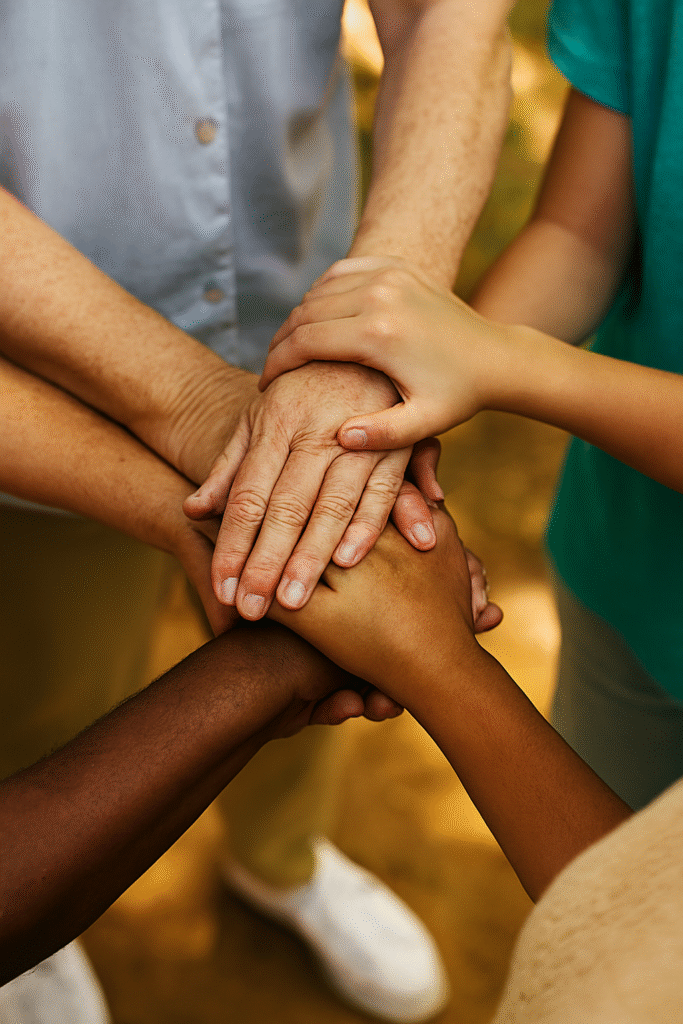 "Bem-estar Integral em 2025: Como Equilibrar Saúde Física e Mental para uma Vida Plena" "Mãos diversas entrelaçadas formando uma rede de apoio, simbolizando solidariedade, cooperação e laços sociais positivos para o bem-estar."